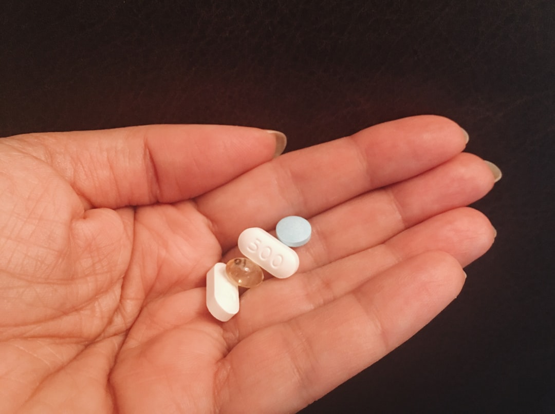 A man looking stressed while holding pills, symbolizing the struggle with addiction.