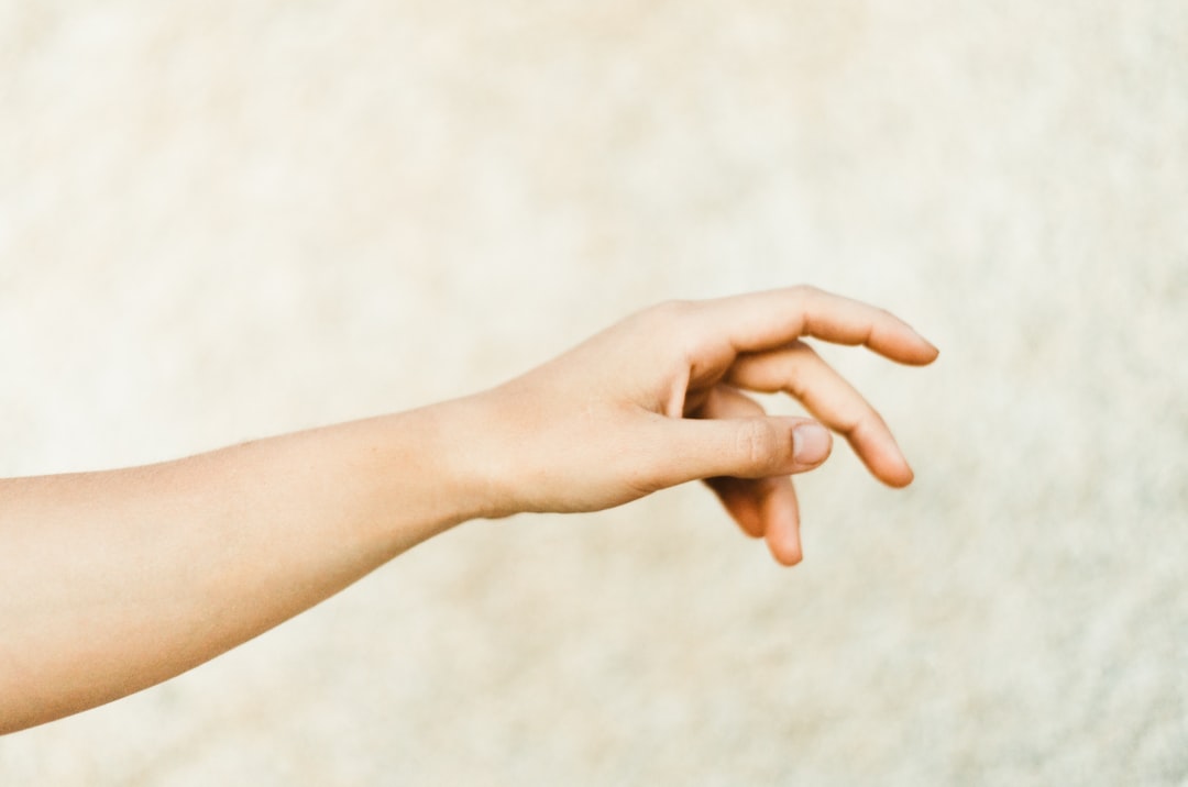 Two people's hands clasped together in a gesture of support.