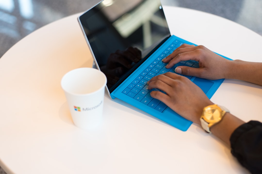 Person sits in a bright, modern room, thoughtfully looking at a laptop screen while researching healthcare information onl...